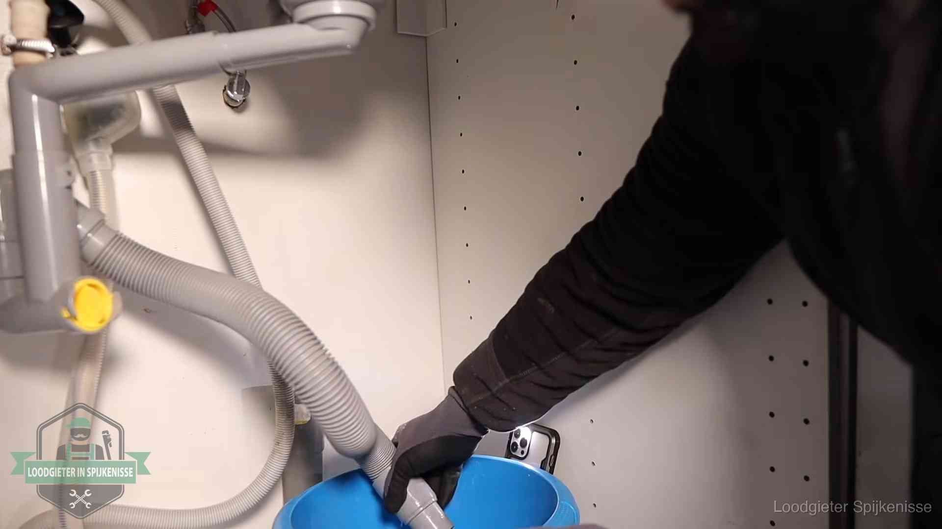 Afvoerslang loopt leeg in een emmer onder de gootsteen in Spijkenisse, een klus die je zelf kunt doen