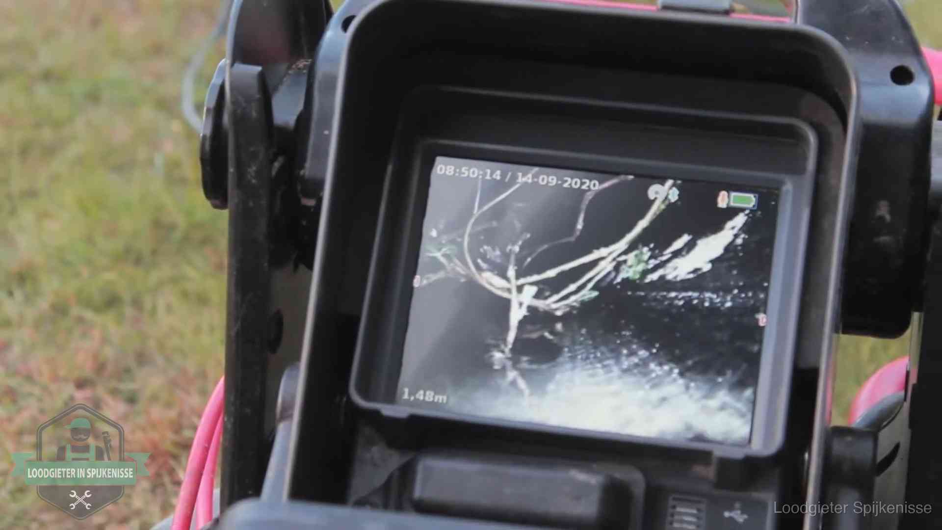 Monitor van een rioolcamera toont wortelingroei in de rioolbuis bij een woning in Spijkenisse