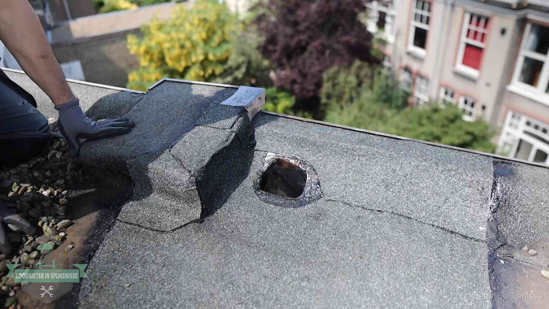 Daklekkage-inspectie op een plat dak in Spijkenisse Loodgieter inspecteert een beschadigd bitumen plat dak tijdens een daklekkage-inspectie in Spijkenisse