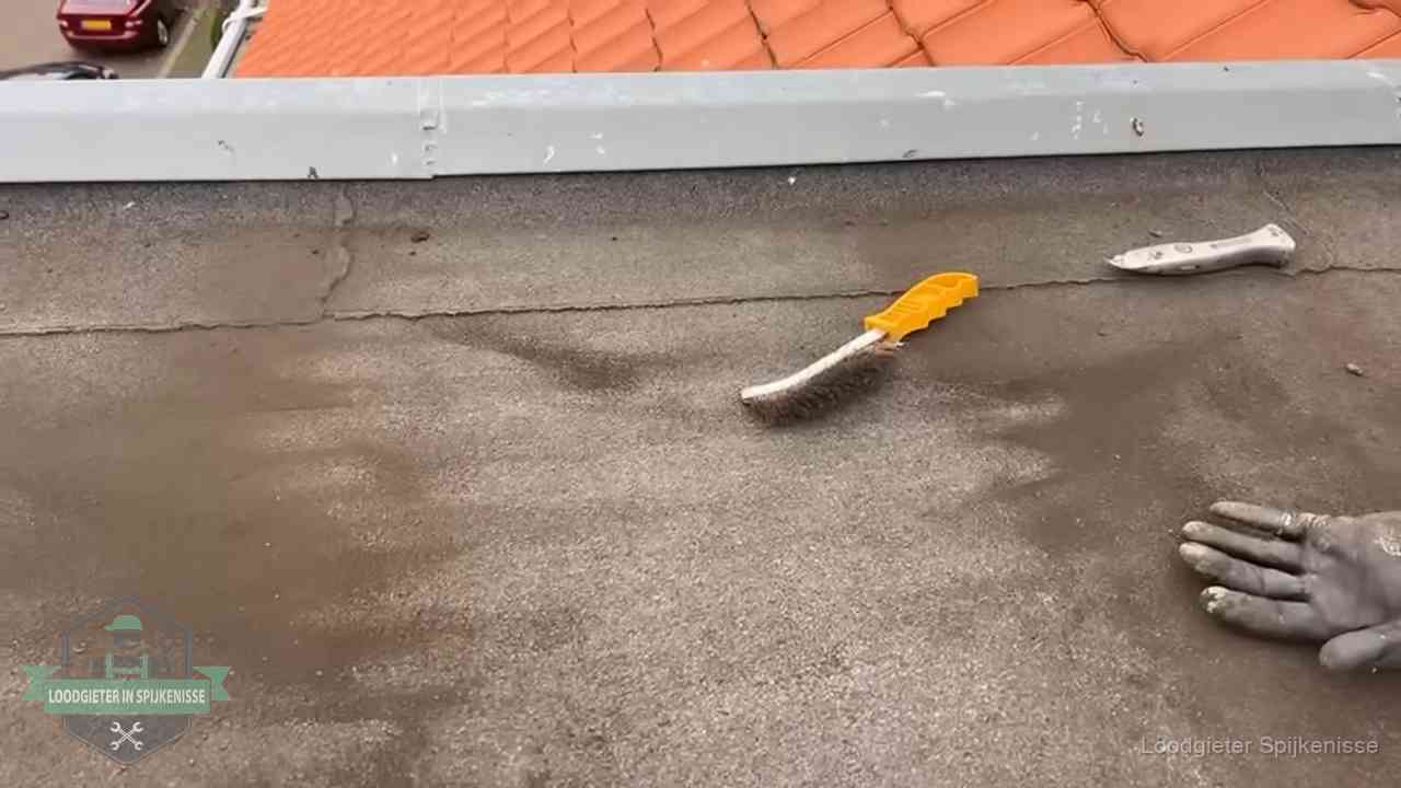 Kosten van daklekkage-reparatie in Spijkenisse Dakdekker bereidt een bitumen plat dak voor op reparatie bij de daktrim in Spijkenisse