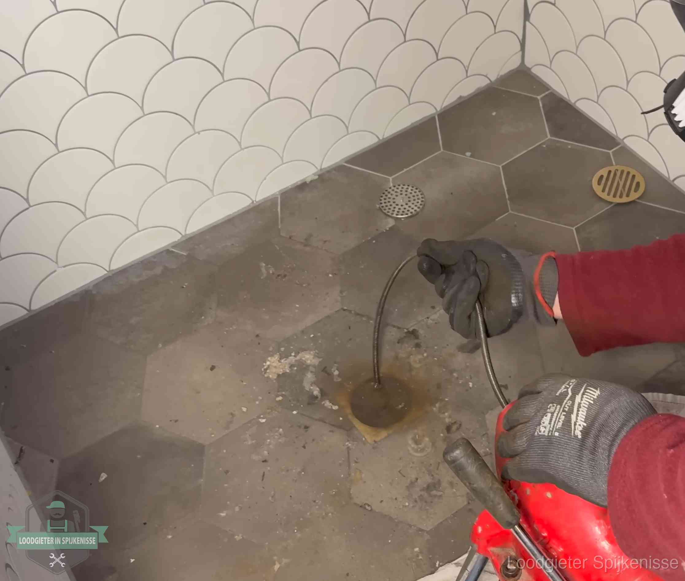 Ontstoppingsveer gaat in een geopend doucheputje in Spijkenisse waar het water omhoogkwam