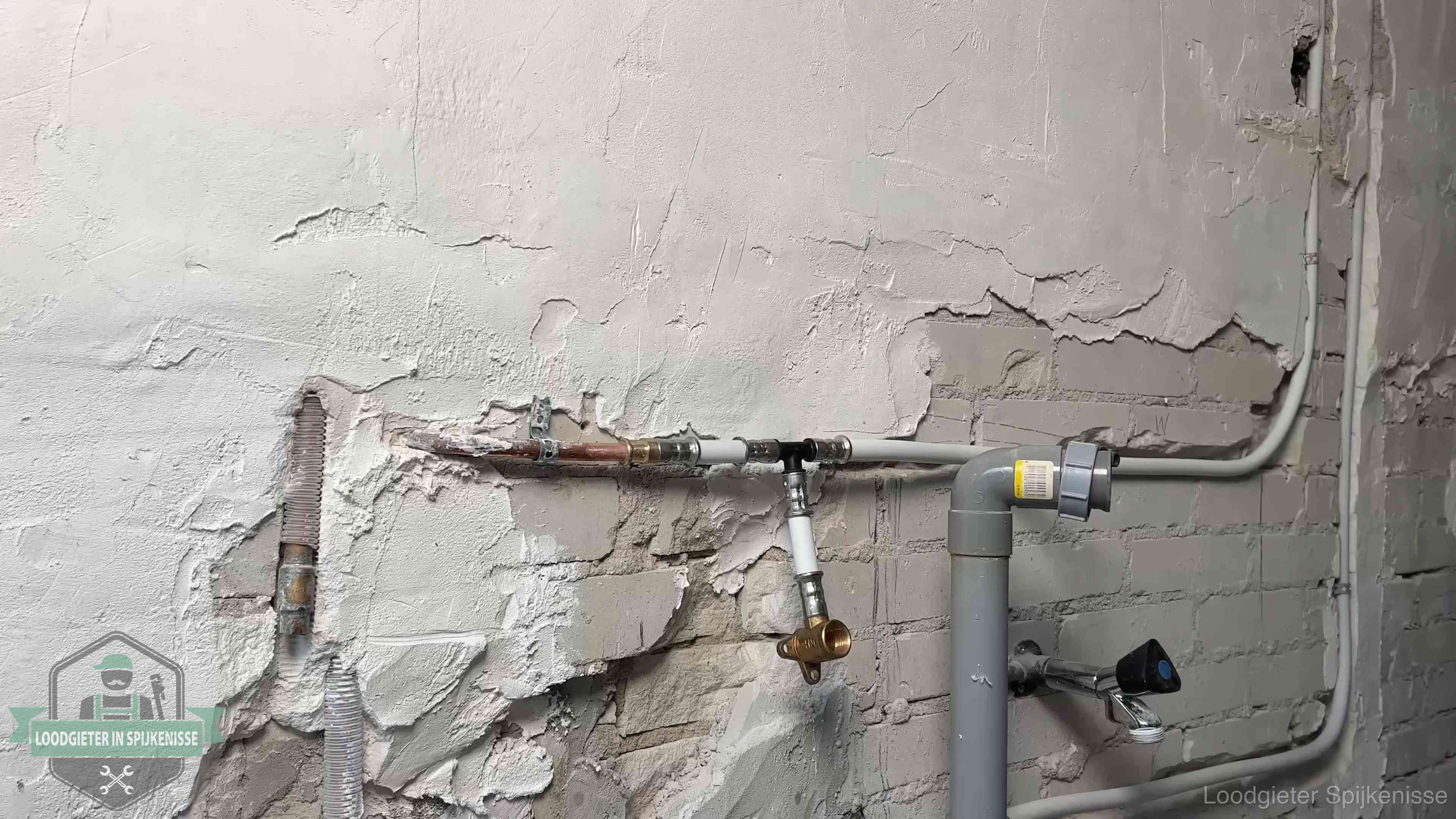 Nieuw leidingwerk naast een oud verroest leidingrestant in een woning in Spijkenisse