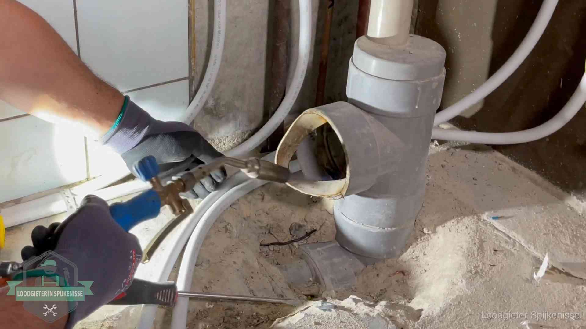 Loodgieter werkt met brander en messing kraanwerk aan leidingen in Spijkenisse