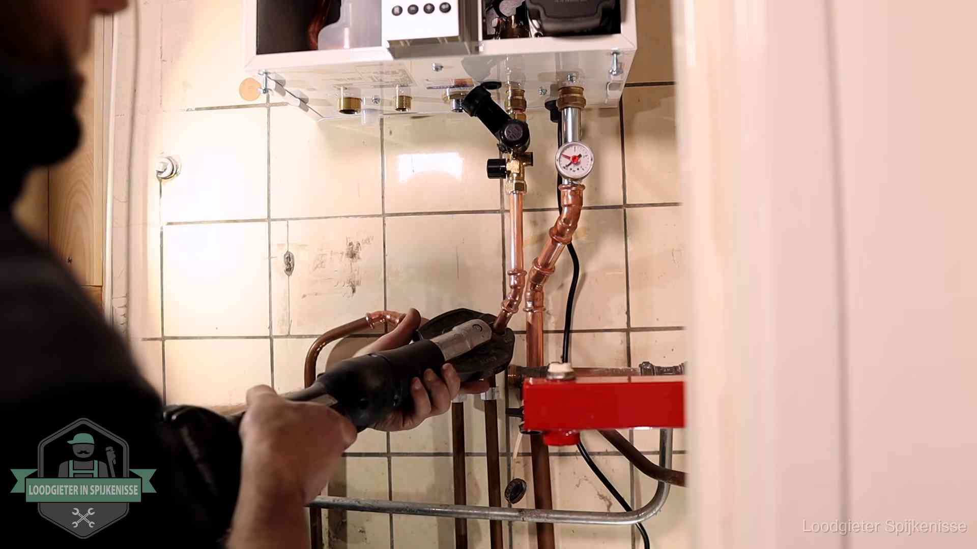 Monteur werkt aan de leidingen onder een cv-ketel in Spijkenisse