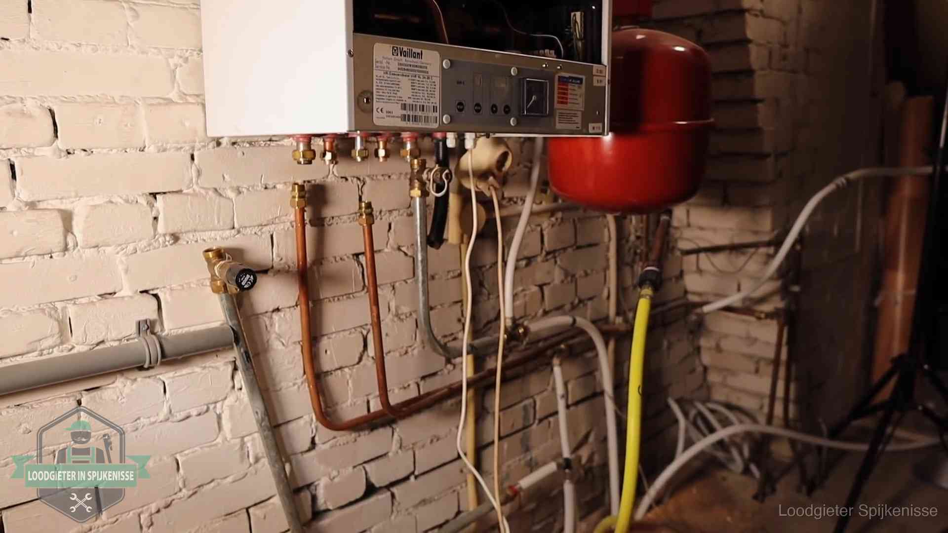 Verouderde cv-ketel met een wirwar van oude leidingen in een woning in Spijkenisse