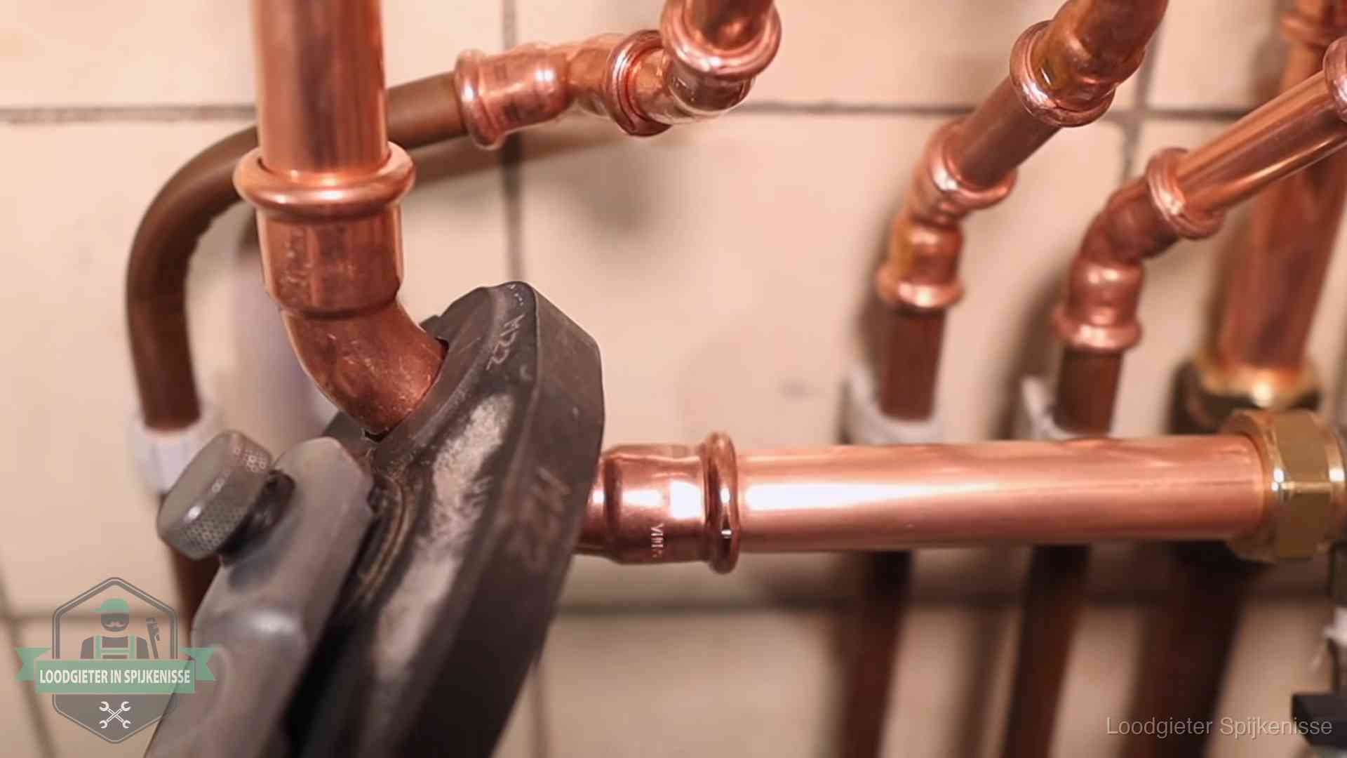 Persmachine perst een koperen fitting op nieuw leidingwerk in Spijkenisse