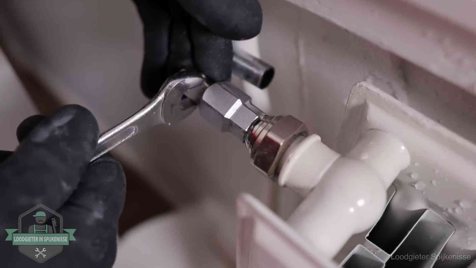 Steeksleutel draait een wartelkoppeling op een radiatorkraan aan in Spijkenisse