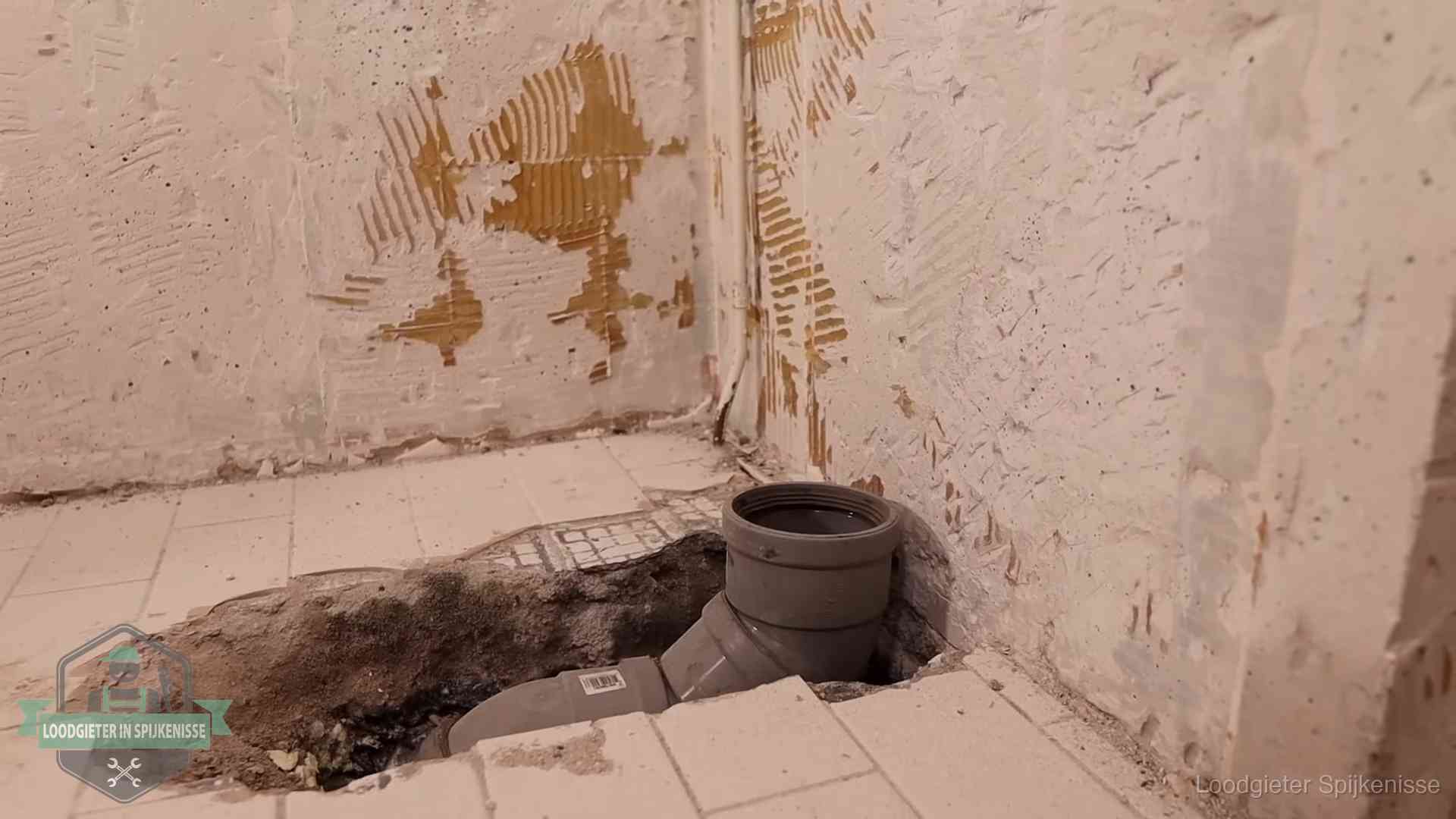 Opengebroken vloer met een nieuwe pvc-rioolbocht in een gegraven sleuf in Spijkenisse