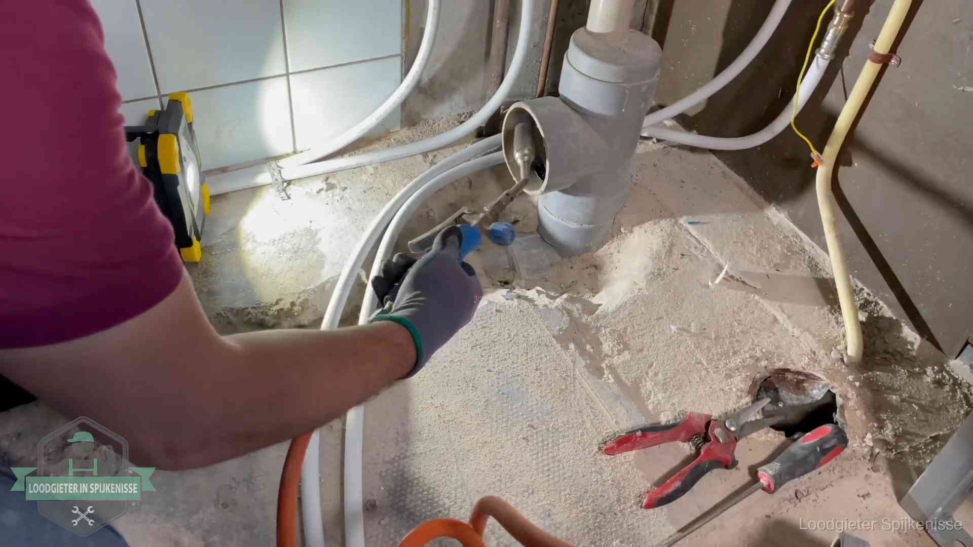 Loodgieter werkt aan leidingen bij een pvc-standleiding in een appartement in Spijkenisse
